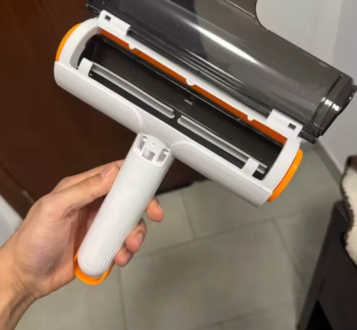 Reusable roller held in one hand with its collection compartment open