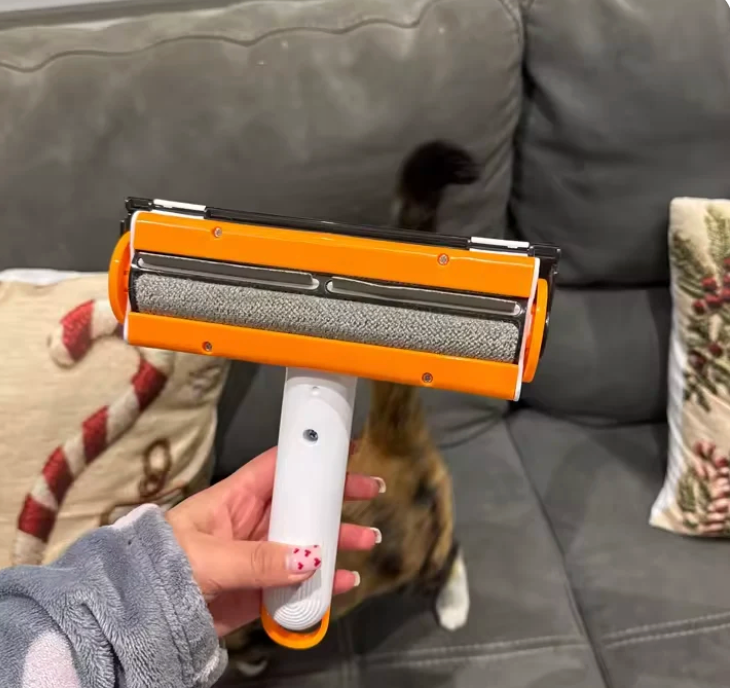 White and orange roller held in front of a fabric sofa